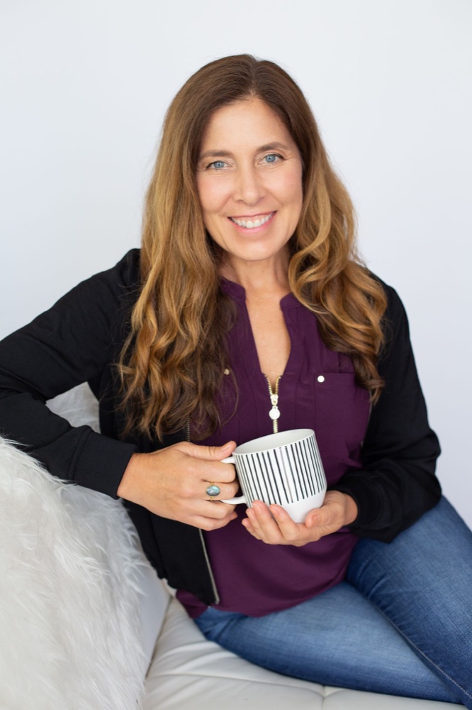 Sienna smiling, holding a mug of tea